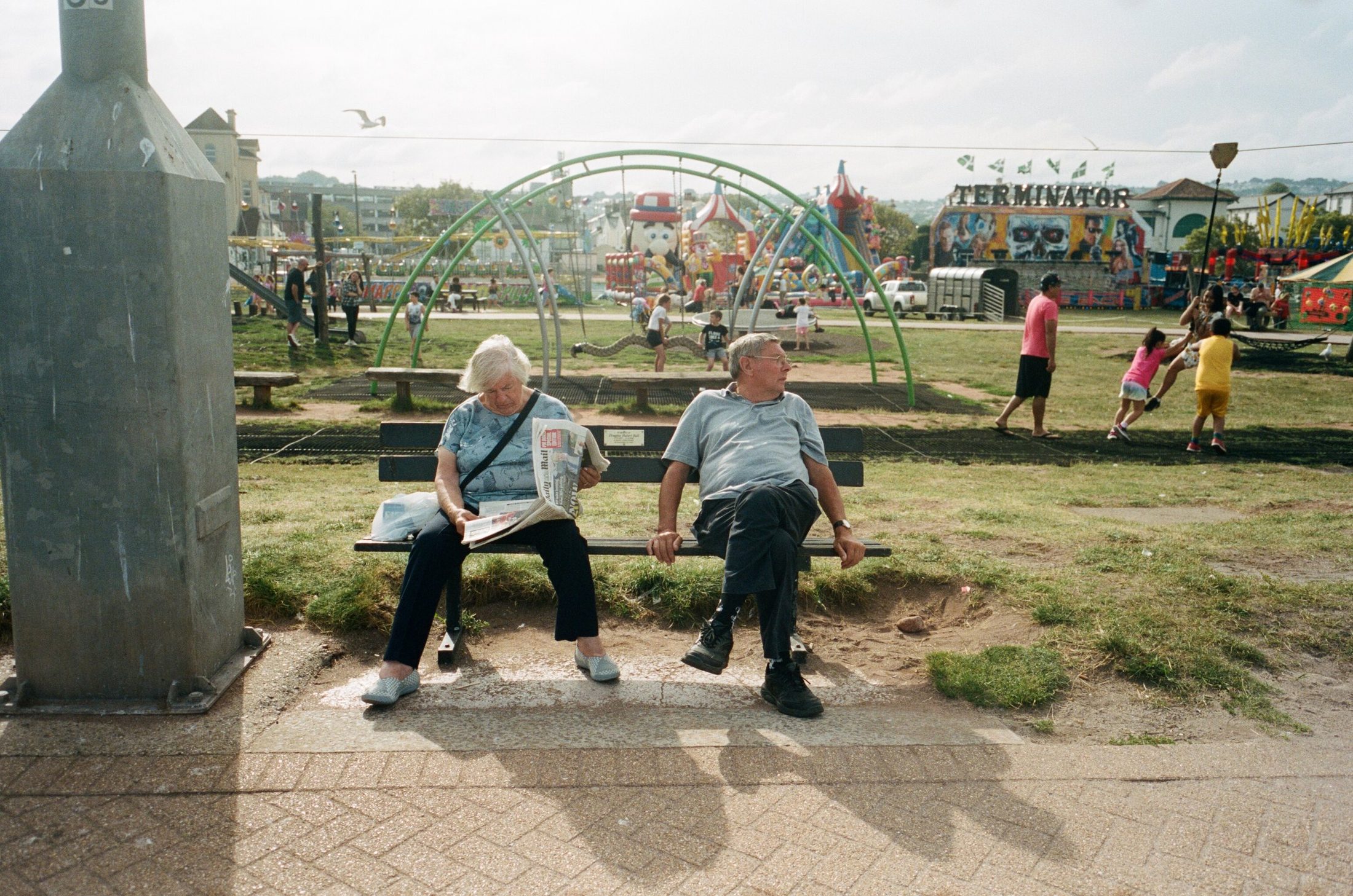 Elderly couple resting on benches by the fair