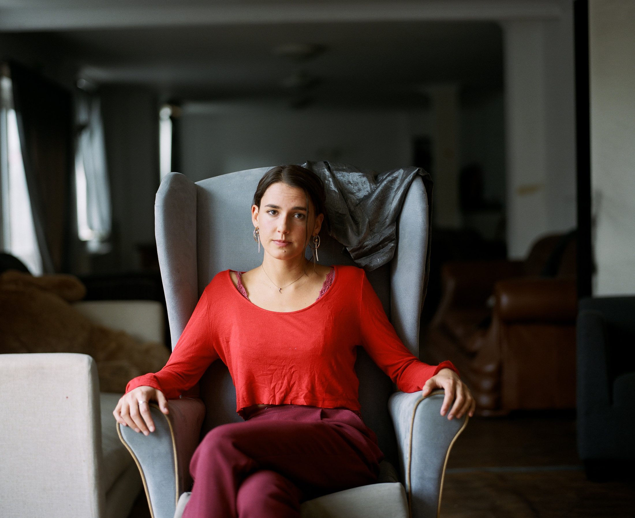 Property guardian in a red jumper, wing-back chair