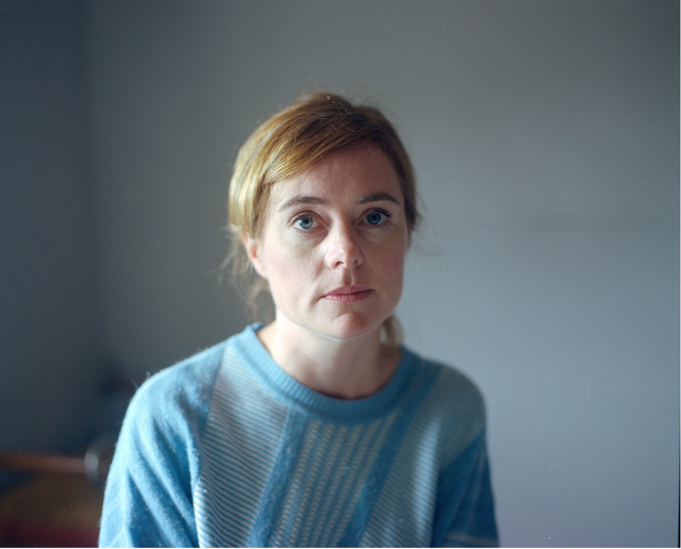Woman in a blue jumper by window light