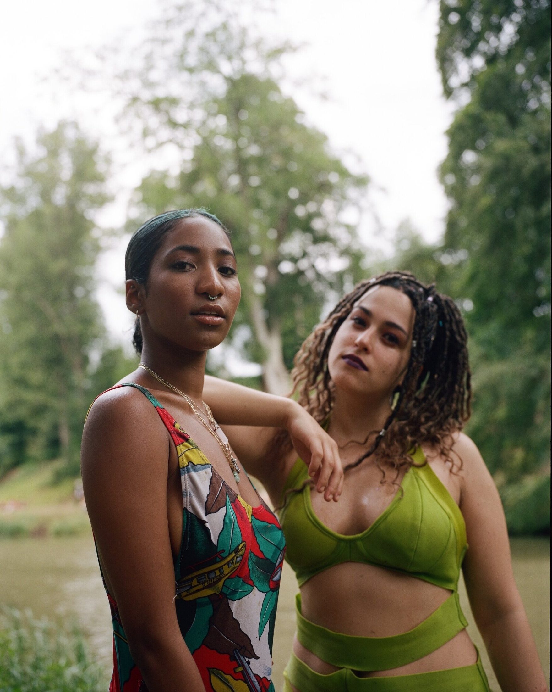 Two sisters standing together by the water