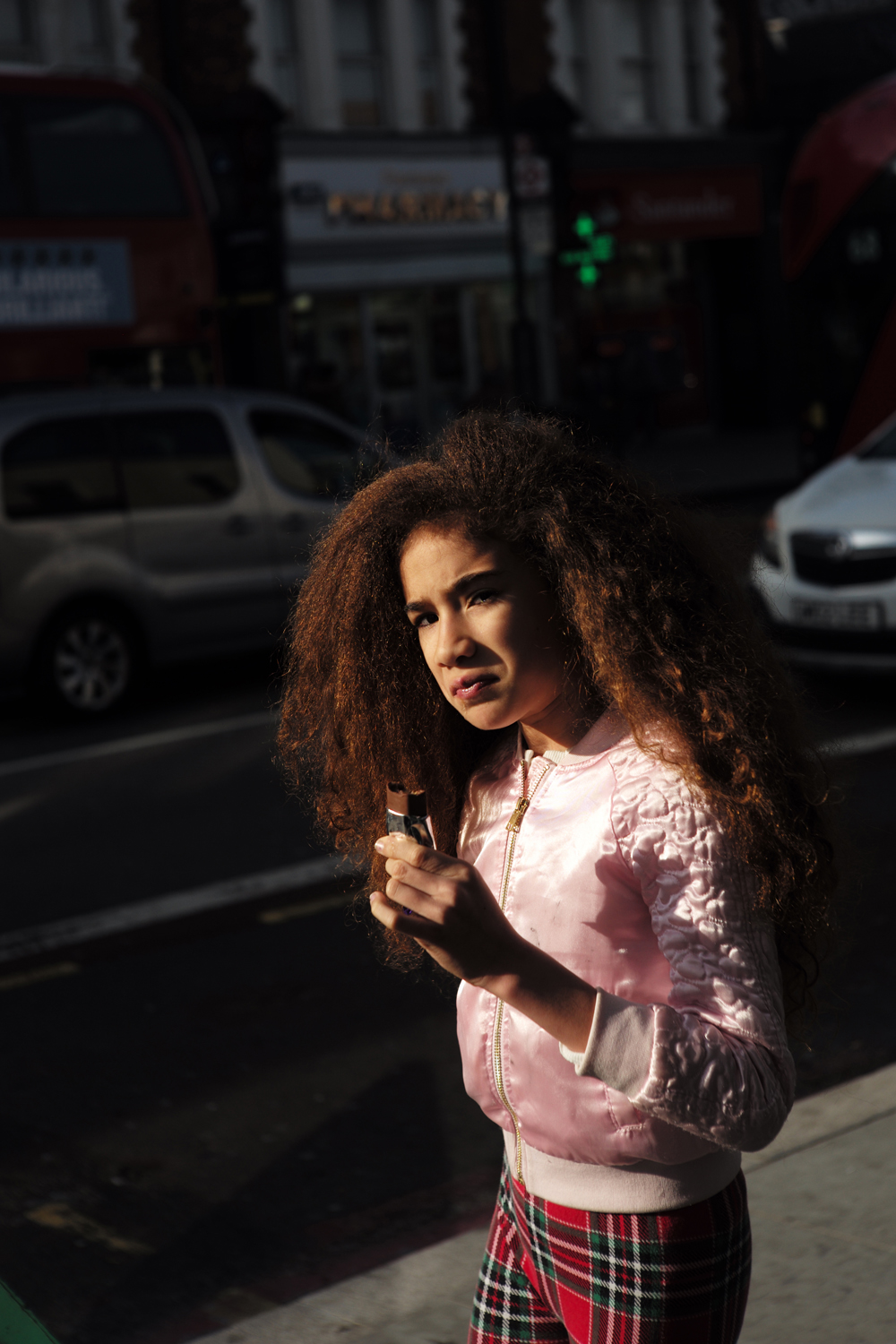 Woman with curled hair crossing the road in low sun