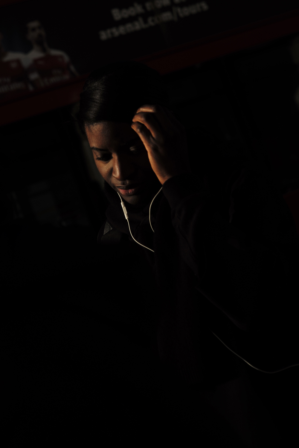 Commuter lit by a blade of light in shadow