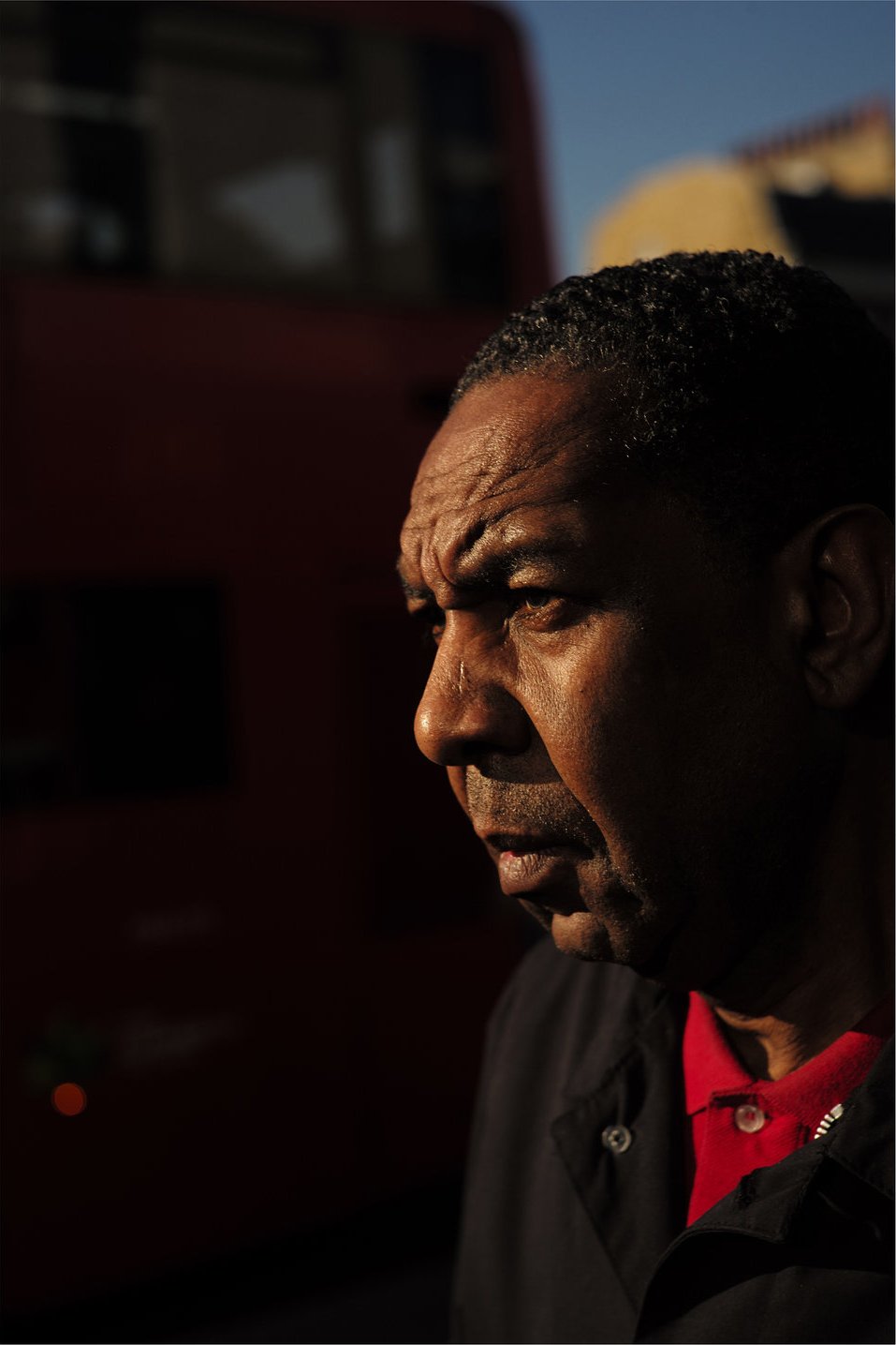 Man in profile against a passing bus, hard light