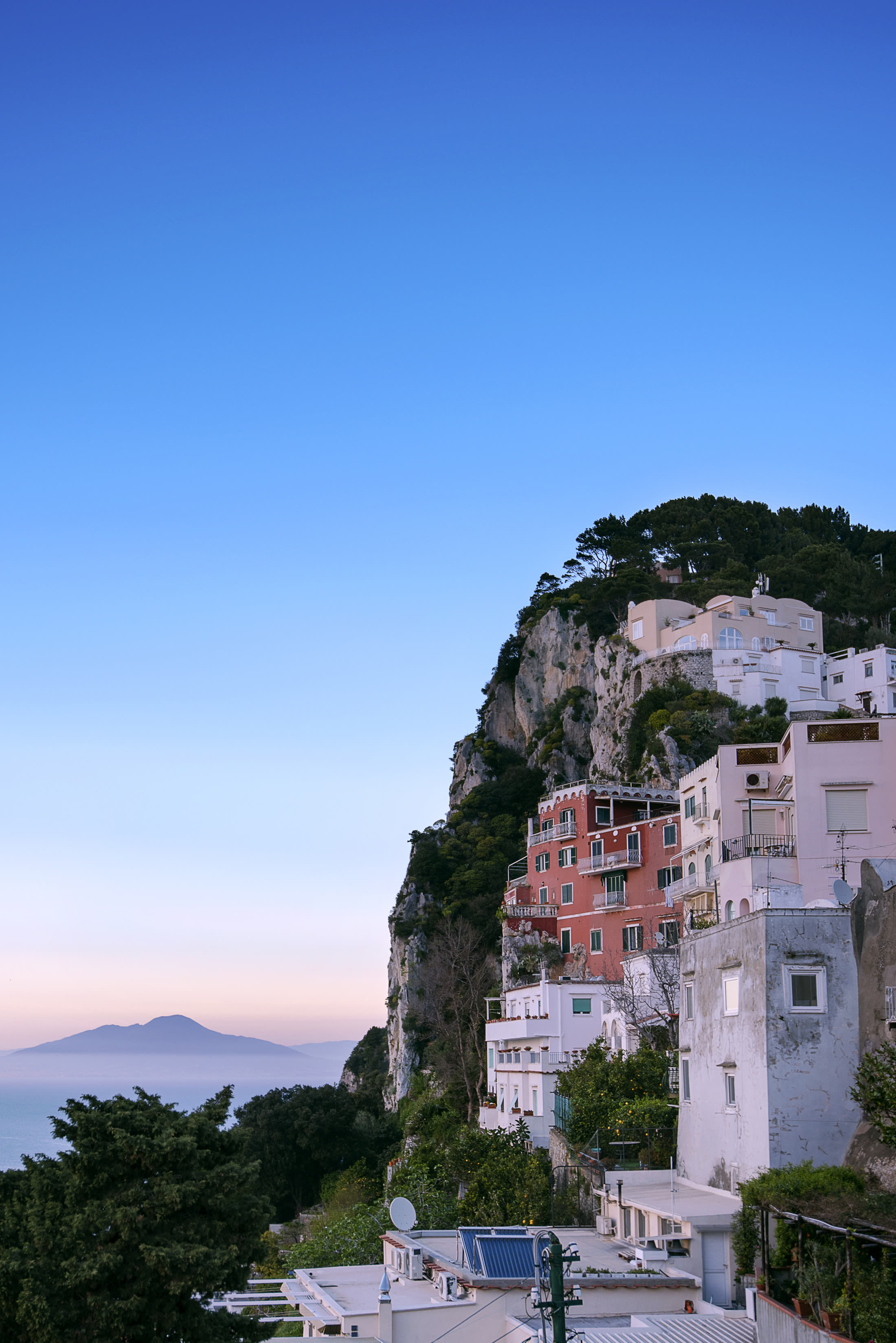 Capri town stacked below the cliff at dusk