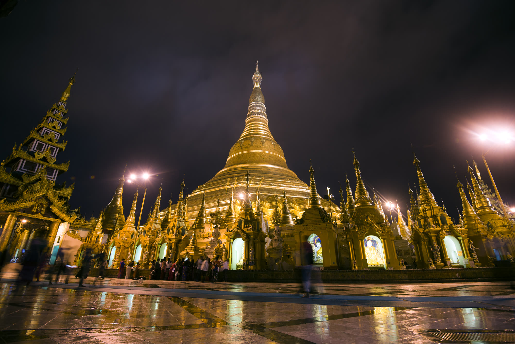 Shwedagon Pagoda lit gold on wet stone, Yangon